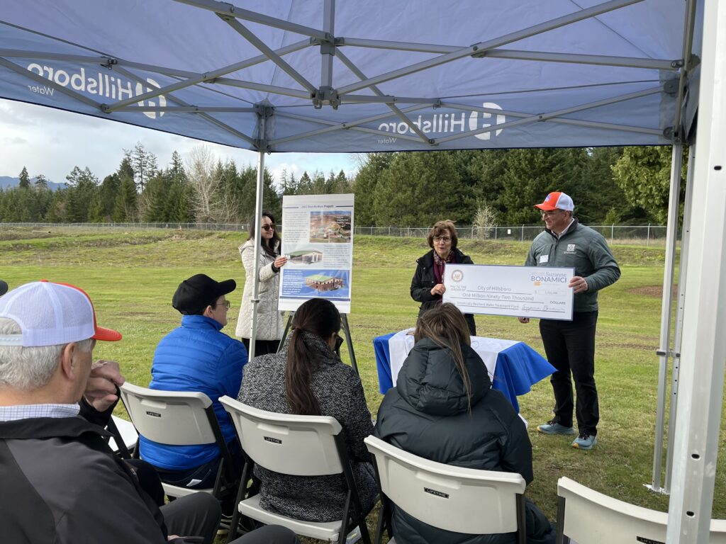 Congresswoman Bonamici exchanging check with JWC Chair Todd Sanders