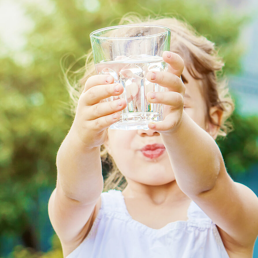 child holding a cup of water
